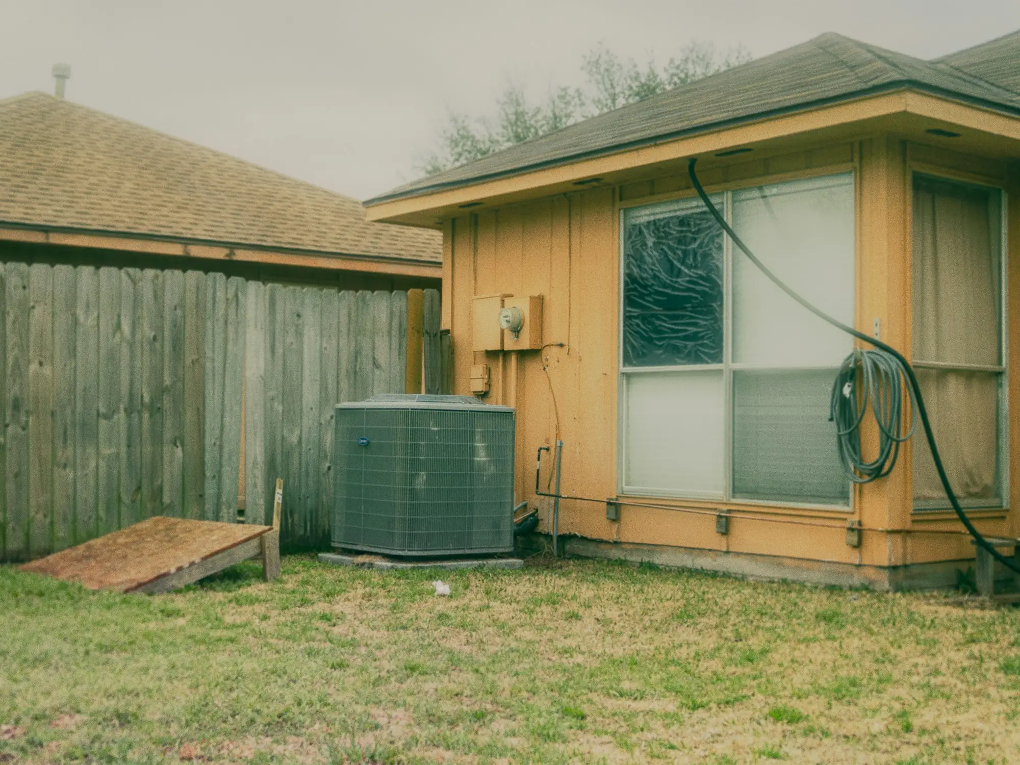A central air conditioning condenser beside a house