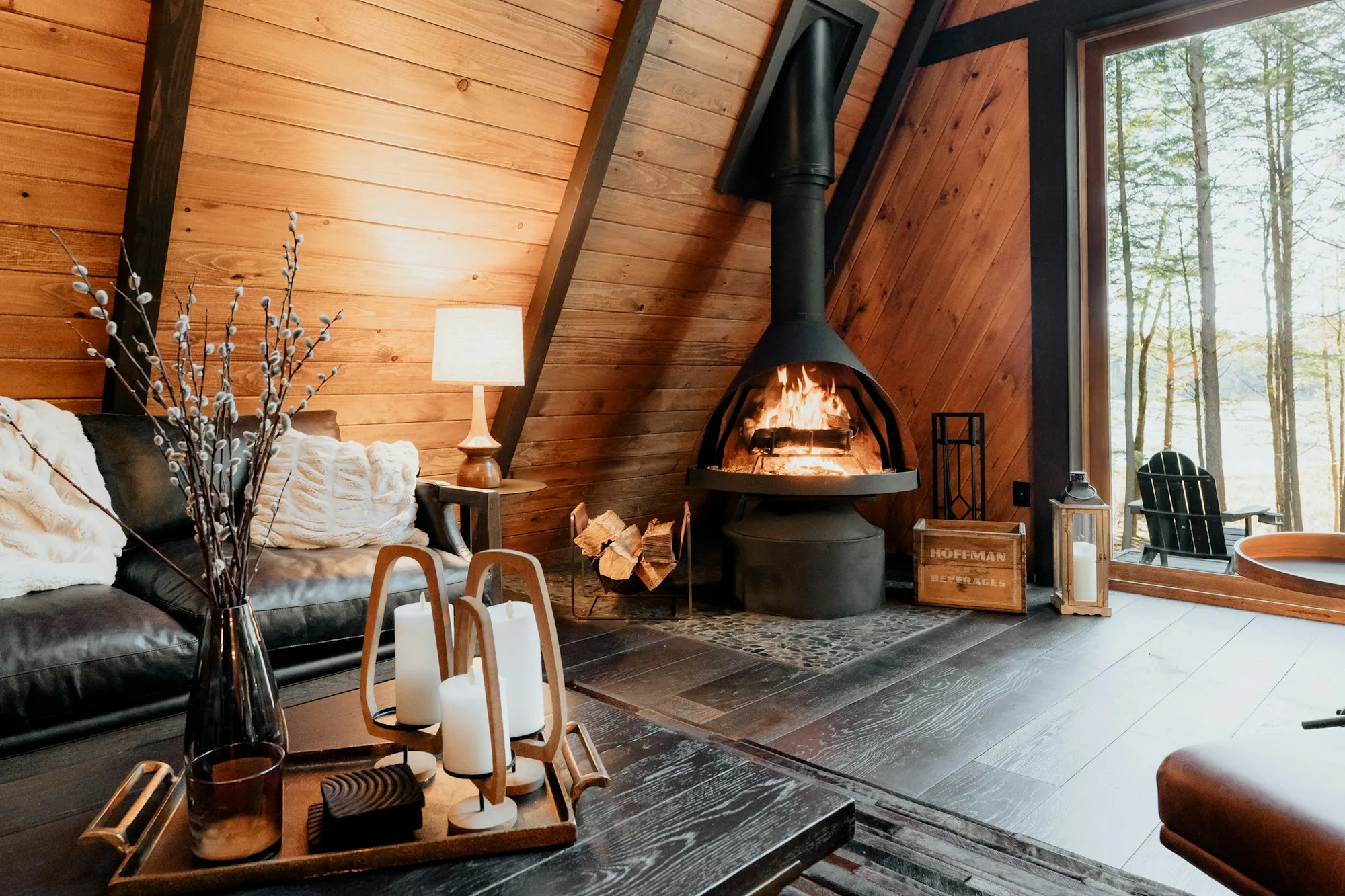 A wood stove burning in a warm A-frame cabin living room